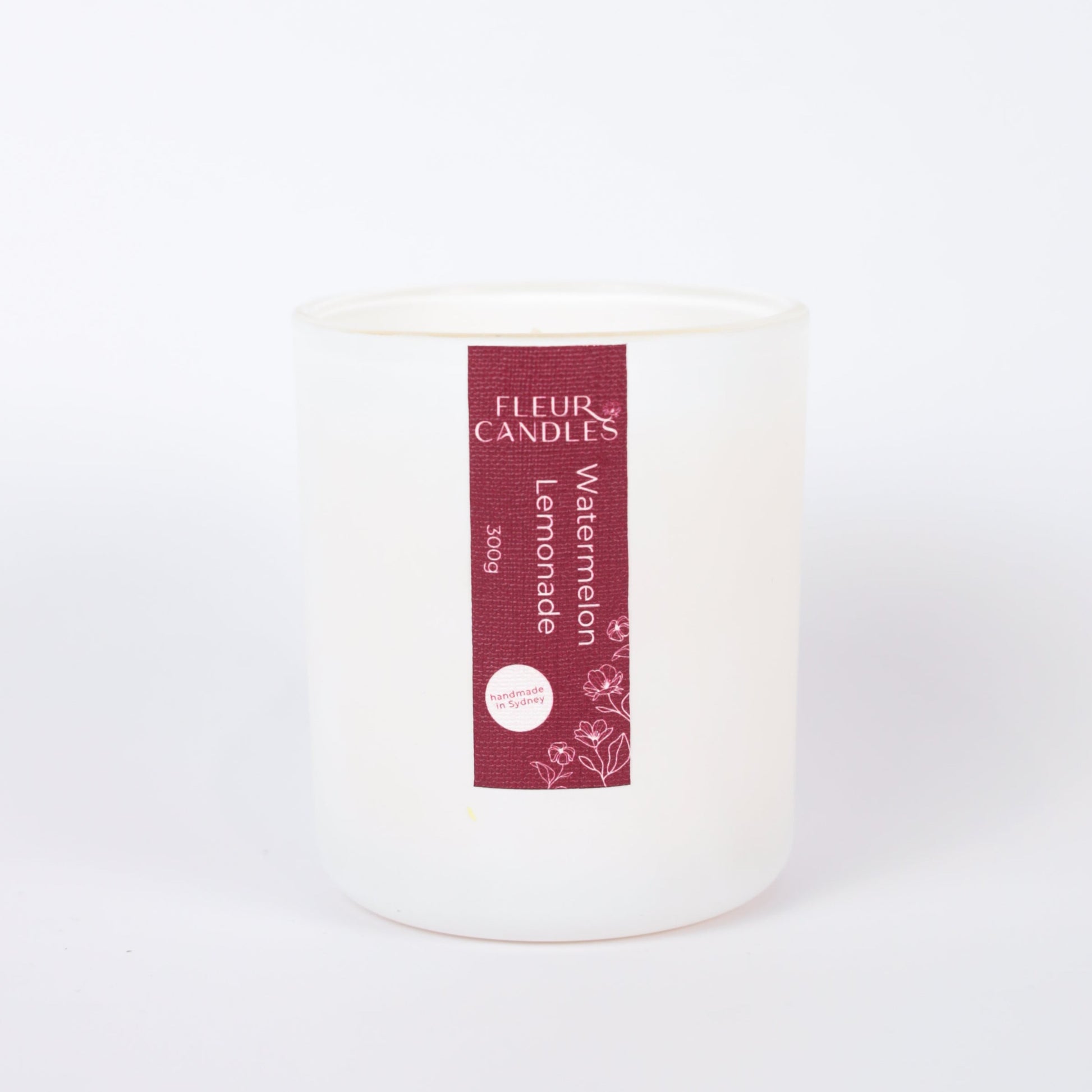 white candle with burgundy label on a white background. fragrance is "watermelon lemonade"